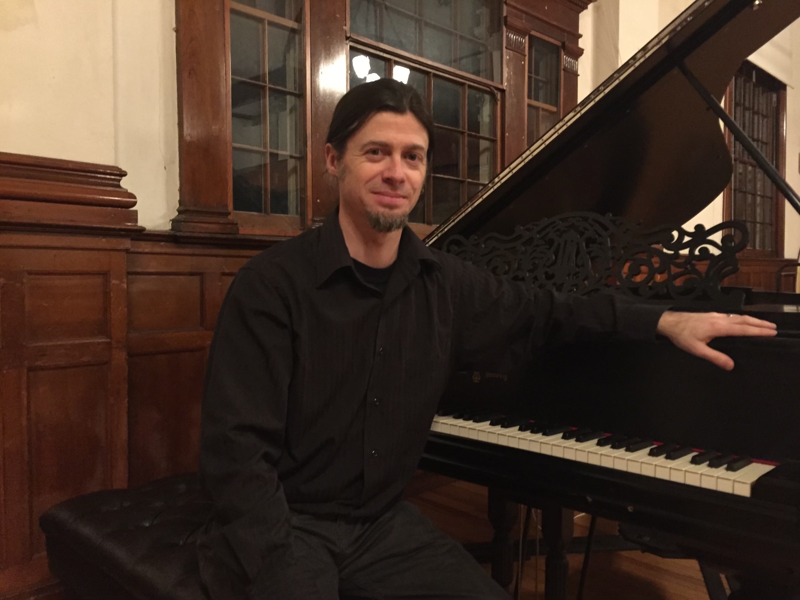 Photo of Trevor Berens sitting at a piano.